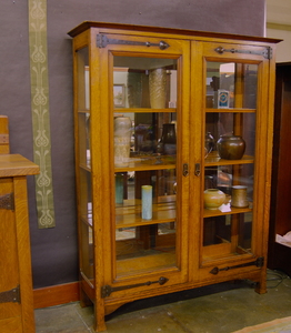 Arts & Crafts Oak Display Cabinet with mirrored back and strap hinges. United Kingdom. circa 1890.